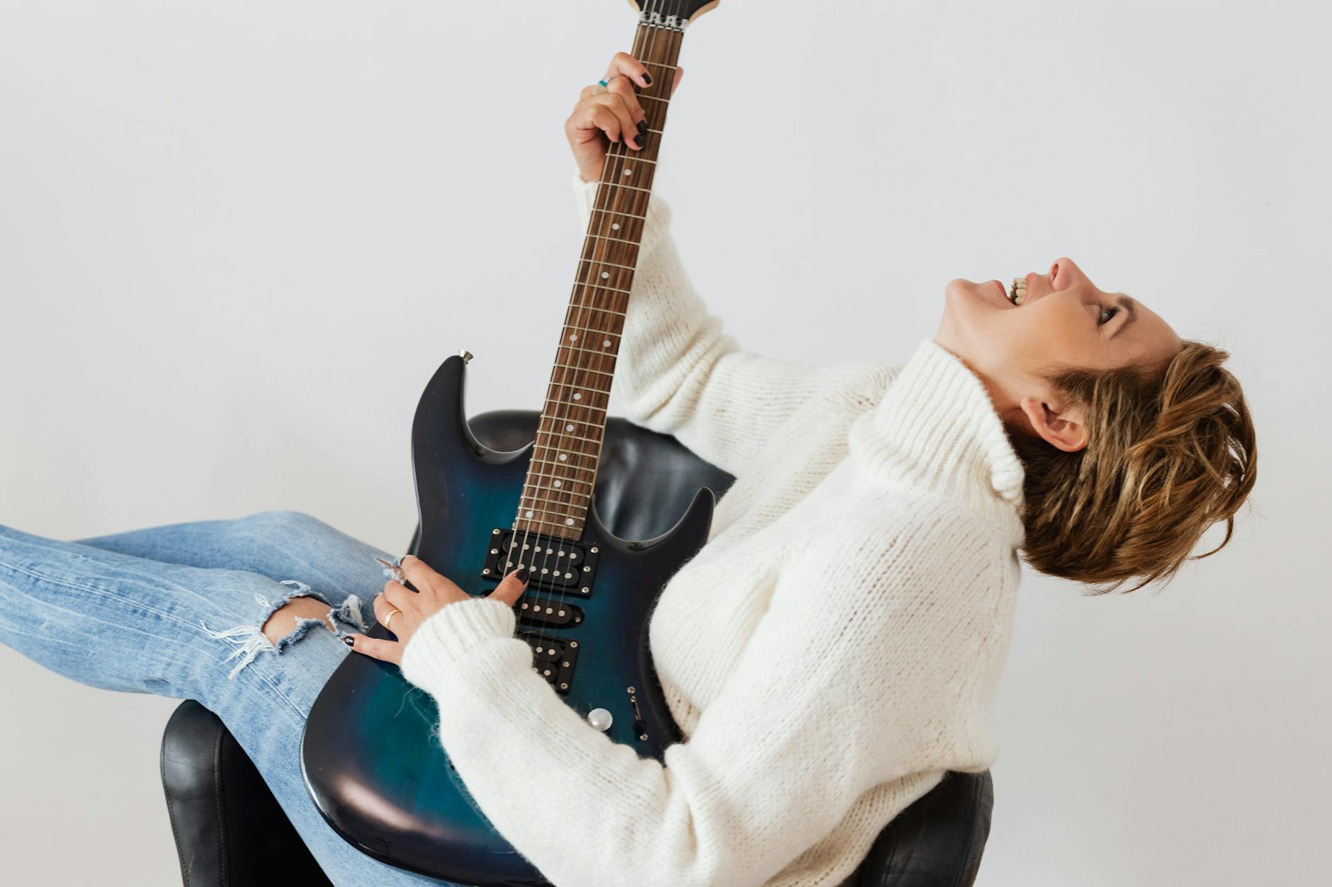 joyful woman having fun while practicing guitar